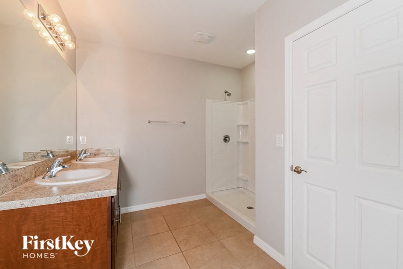 a bathroom with two sinks and a shower and a mirror