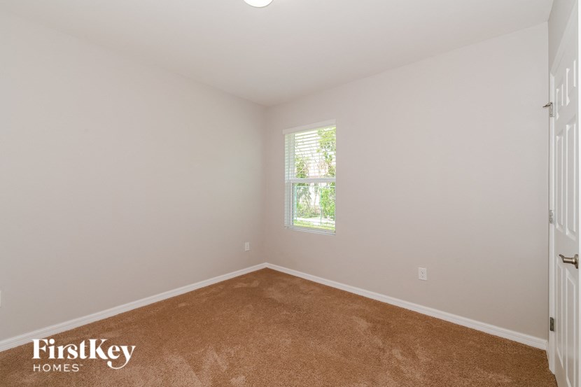 a white room with a window and a brown carpet