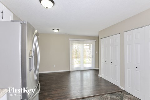 A kitchen with a refrigerator and a dining table.