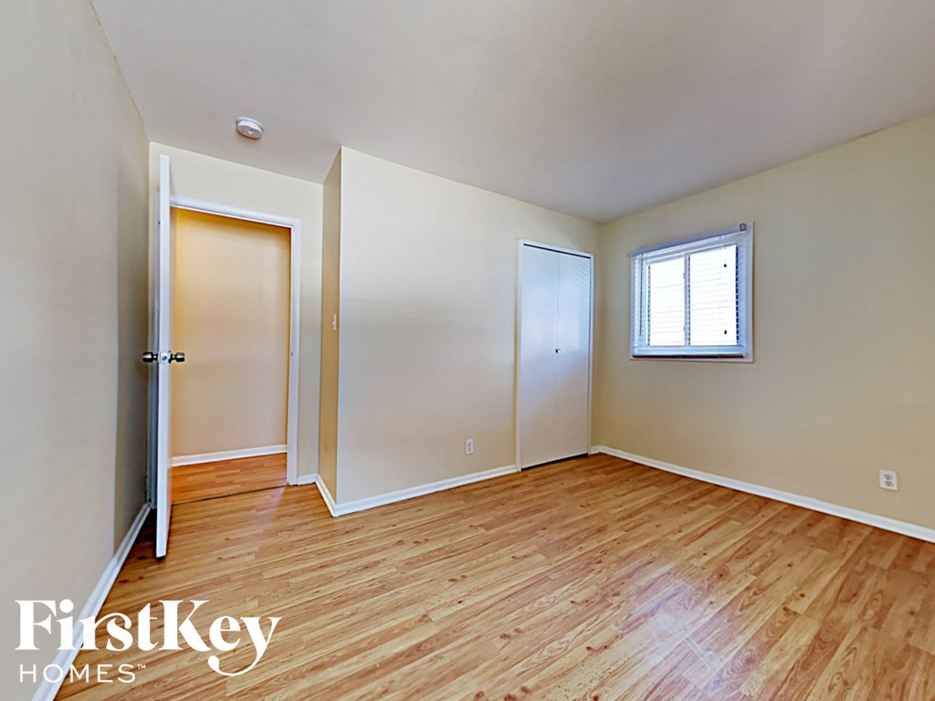 an empty living room with wood flooring and white walls