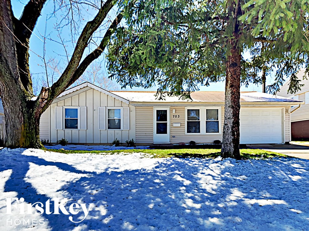 a white house with trees in the snow