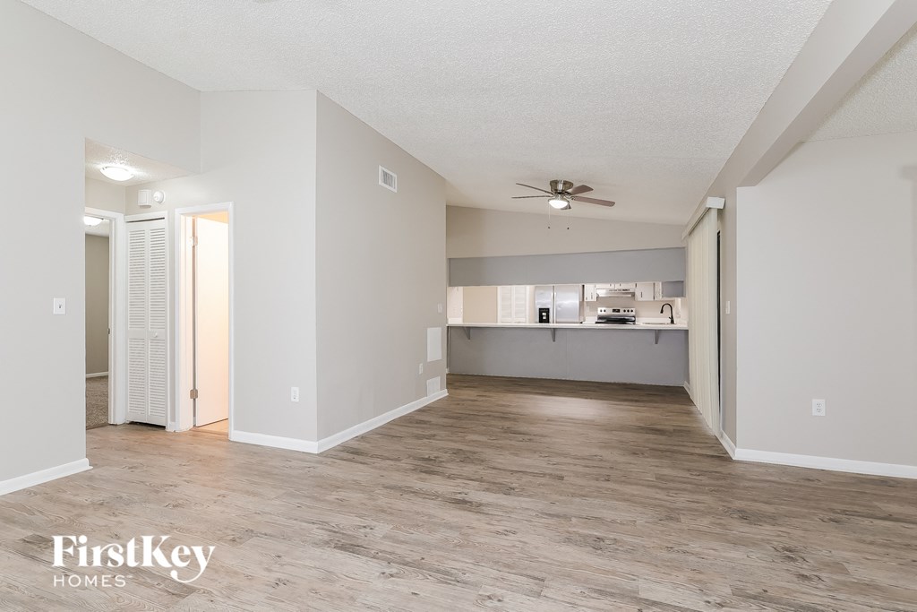 a living room and kitchen with a ceiling fan