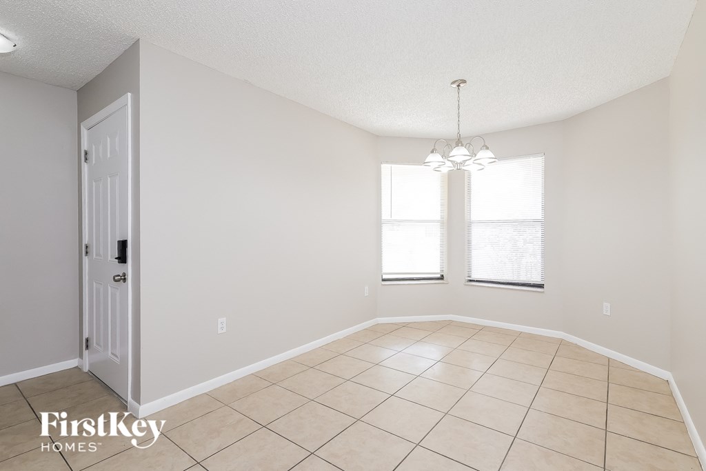 a dining room with a tiled floor and a window