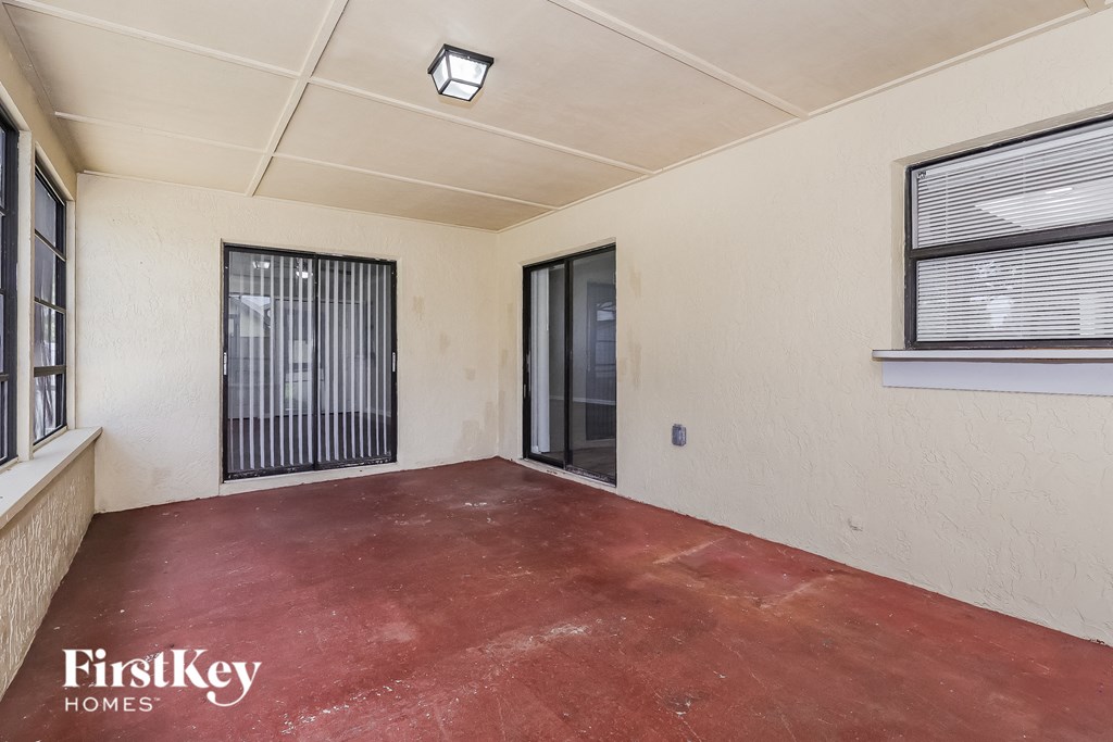 an empty room with a sliding glass door and a window