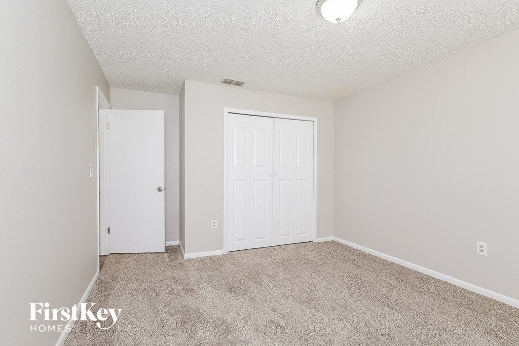 a bedroom with two closets and a carpeted floor