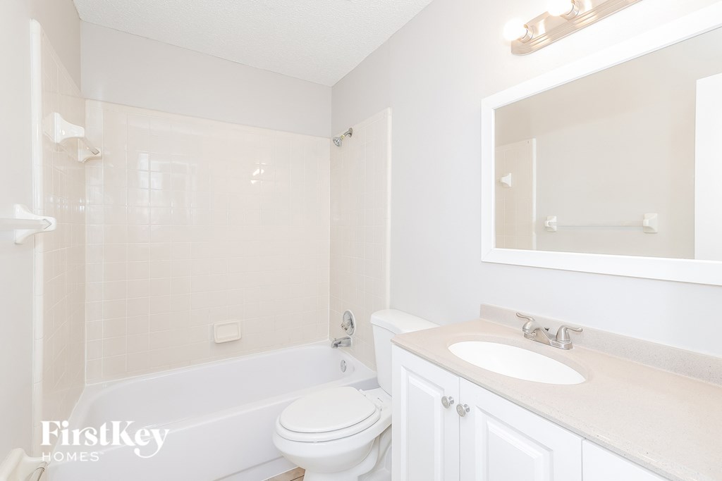 a white bathroom with a sink toilet and bath tub