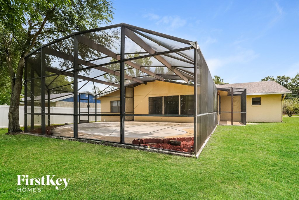 a glass enclosure with a house in the background