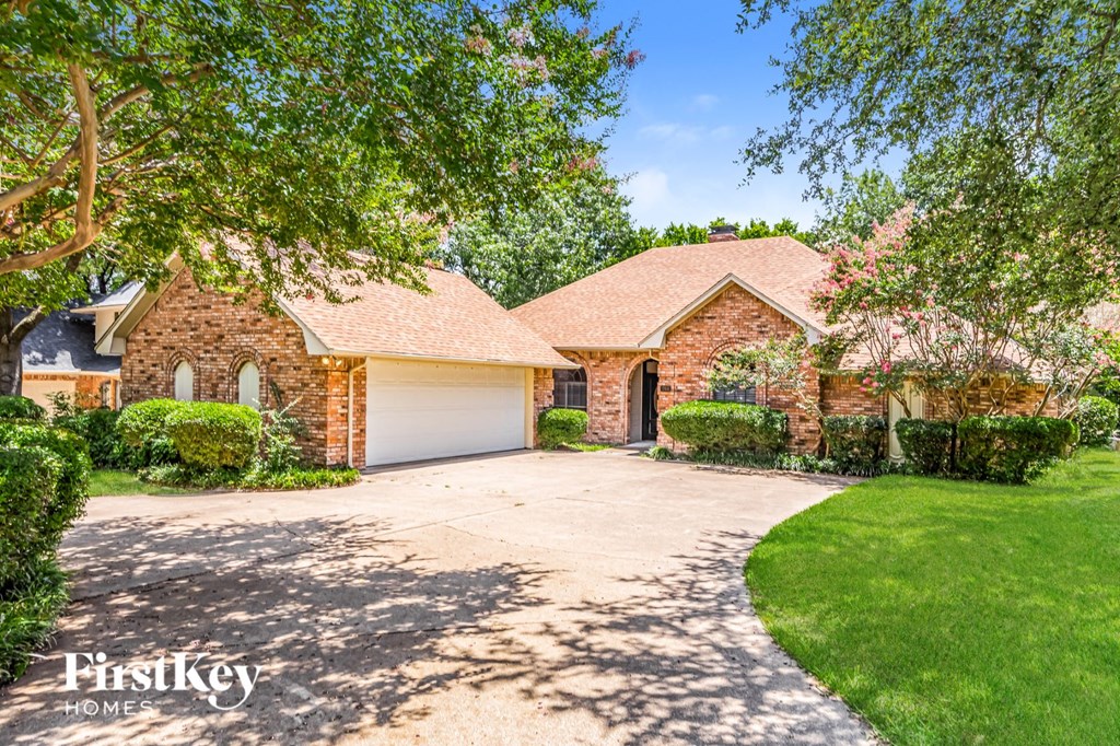 a large brick house with a driveway and a garage door