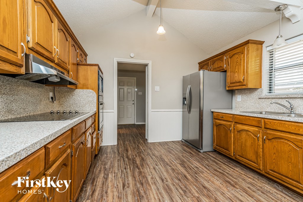 a kitchen with wooden cabinets and a stainless steel refrigerator