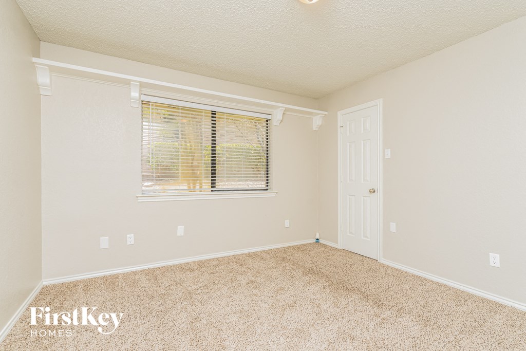 a bedroom with carpet and a window and a door