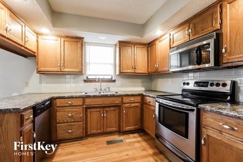 A kitchen with wooden cabinets and a black stove top oven.