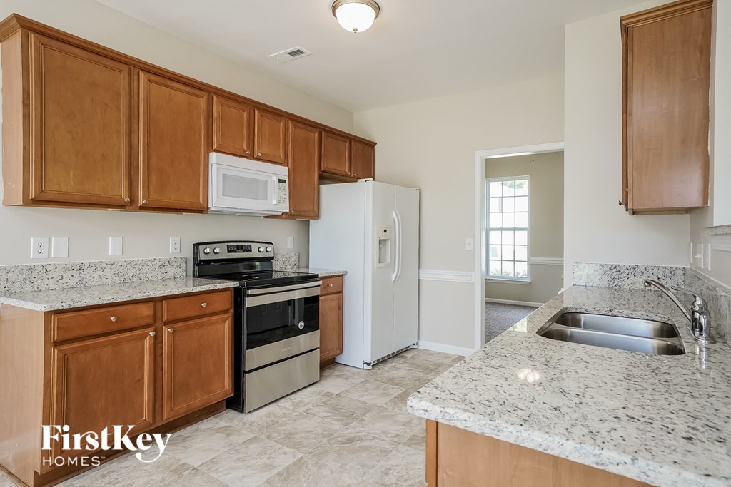 A kitchen with wooden cabinets and granite countertops.