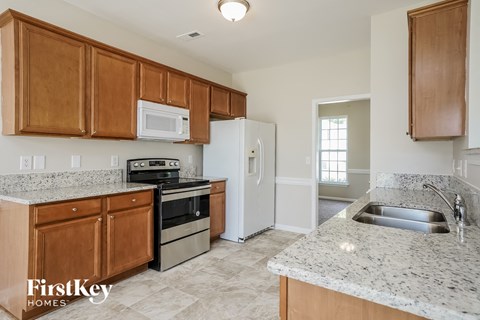 A kitchen with wooden cabinets and granite countertops.