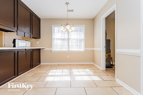 A kitchen with brown cabinets and a white fridge.