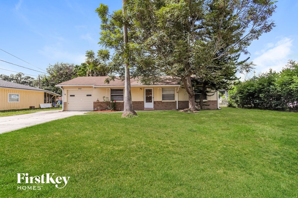 A house with a lawn and trees in front of it.