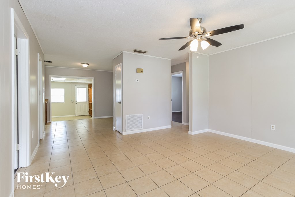 A spacious room with a ceiling fan and tiled flooring.