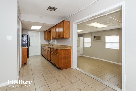 A kitchen with wooden cabinets and a refrigerator.