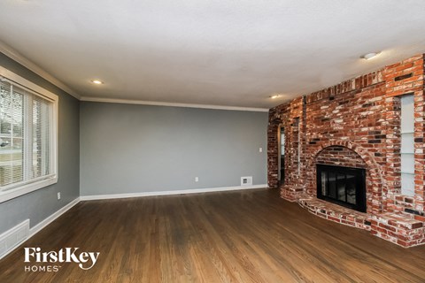 the living room of a house with a brick fireplace