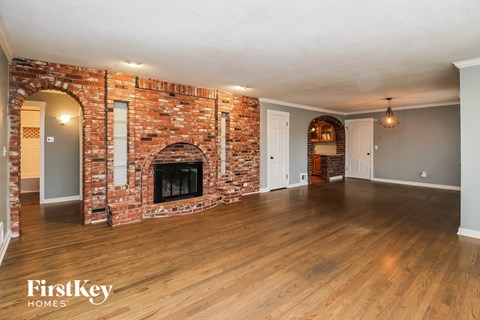 the living room of a house with a brick fireplace
