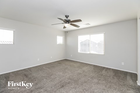 a living room with carpet and a ceiling fan