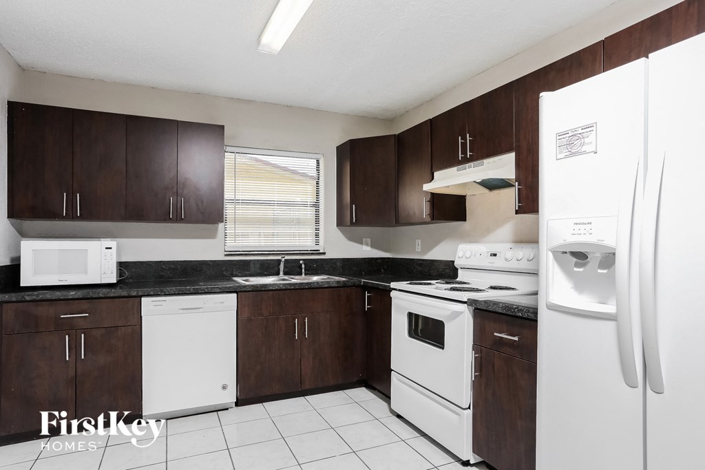 a kitchen with white appliances and wooden cabinets