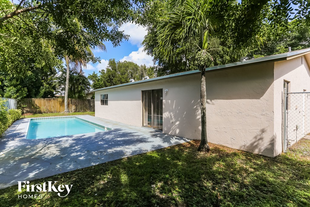 a backyard with a pool and a white house