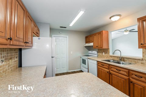 a kitchen with white appliances and wooden cabinets