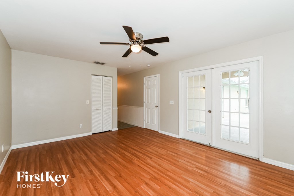 a living room with wood floors and a ceiling fan