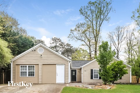 the exterior of a house with a garage and a driveway