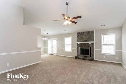 a living room with a fireplace and a ceiling fan