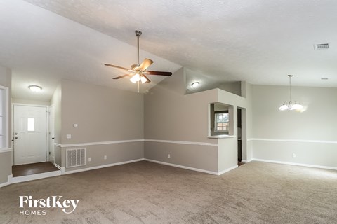 the living room of an empty house with a ceiling fan