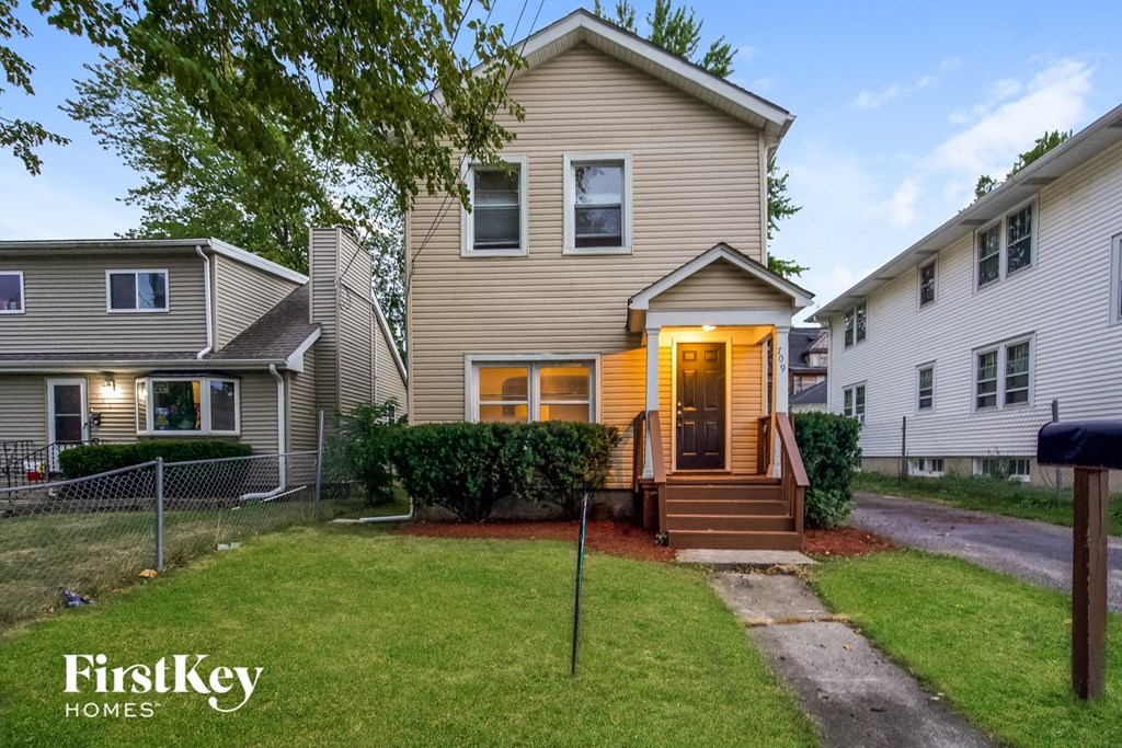 the front of a house with a yard and a sidewalk