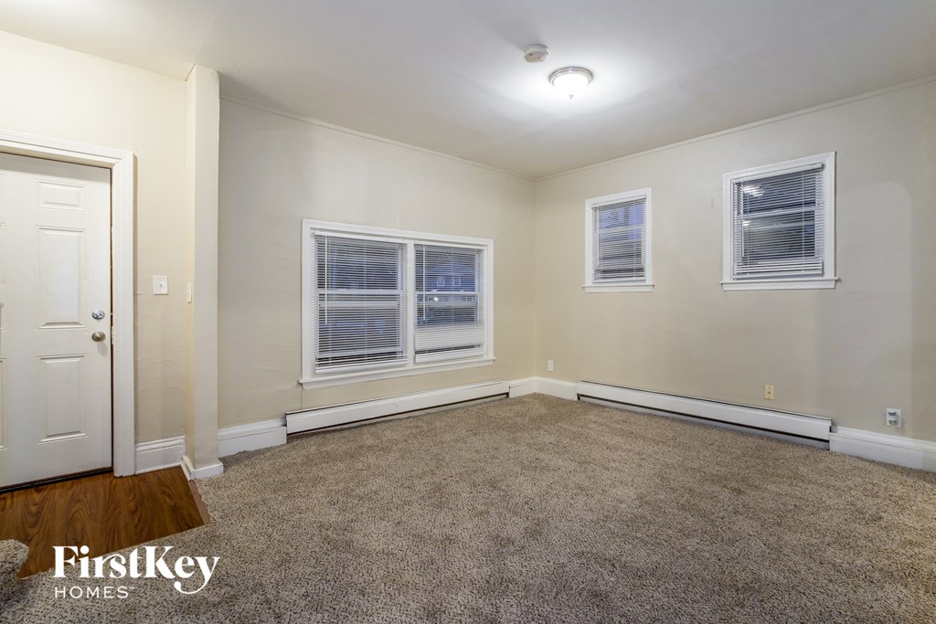 a bedroom with a carpeted floor and three windows