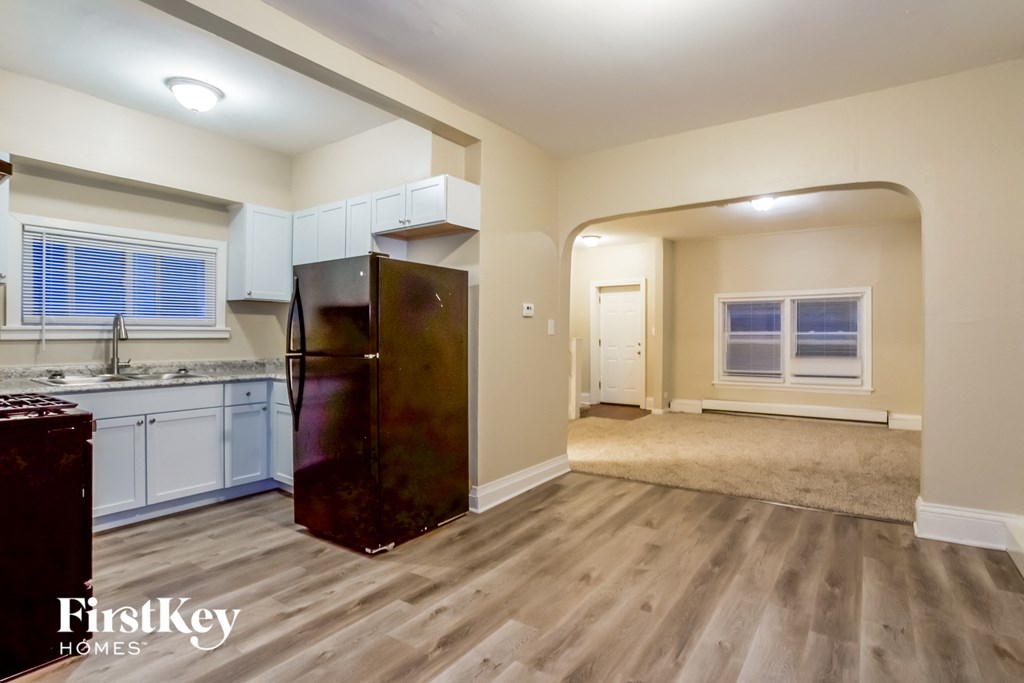 a kitchen and living room with a refrigerator and a sink