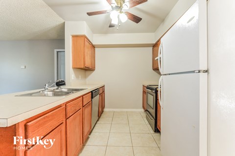 a kitchen with wooden cabinets and a sink and a refrigerator