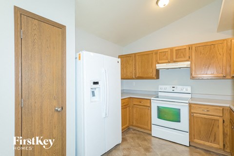 A kitchen with wooden cabinets and a white fridge.