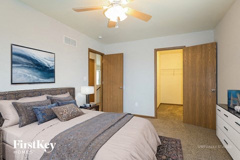 A bedroom with a large bed and a ceiling fan.