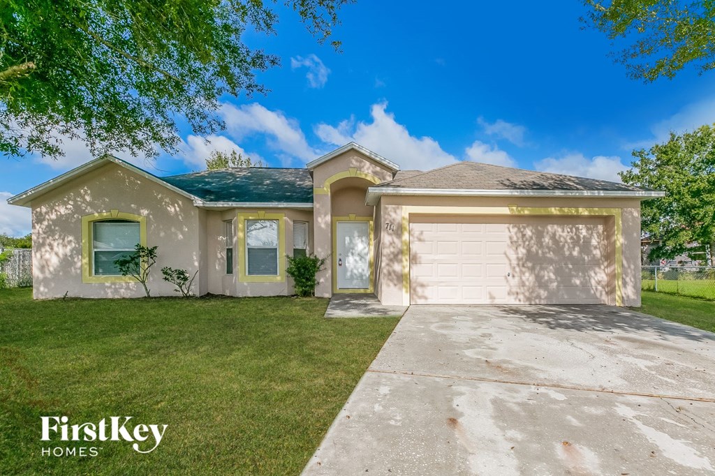 a beige house with a white garage door and a lawn