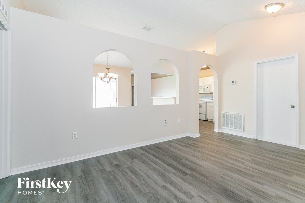 a living room with white walls and wood floors