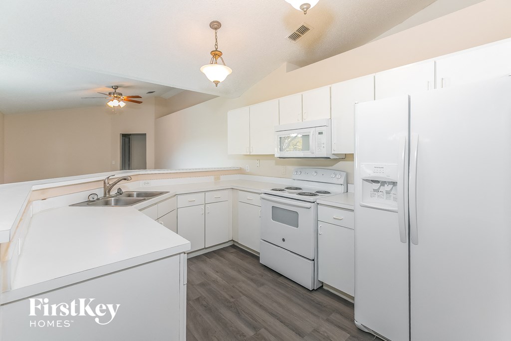 a white kitchen with white appliances and white cabinets