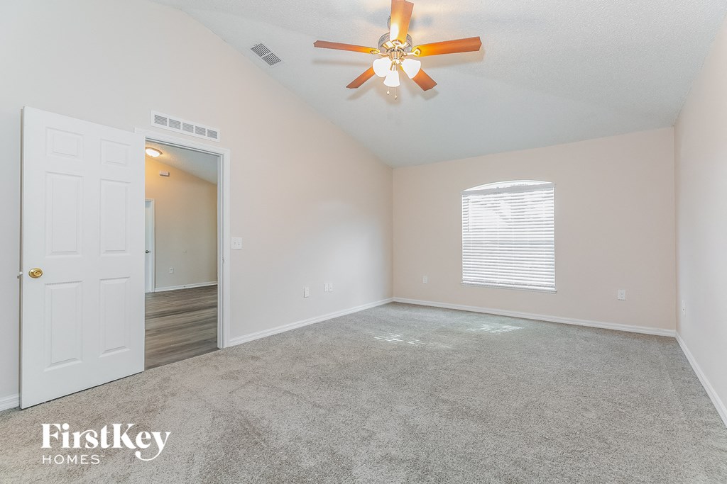 the living room of an empty house with a ceiling fan