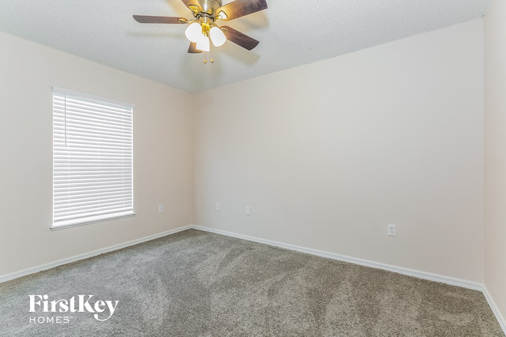 the living room of an empty house with a ceiling fan