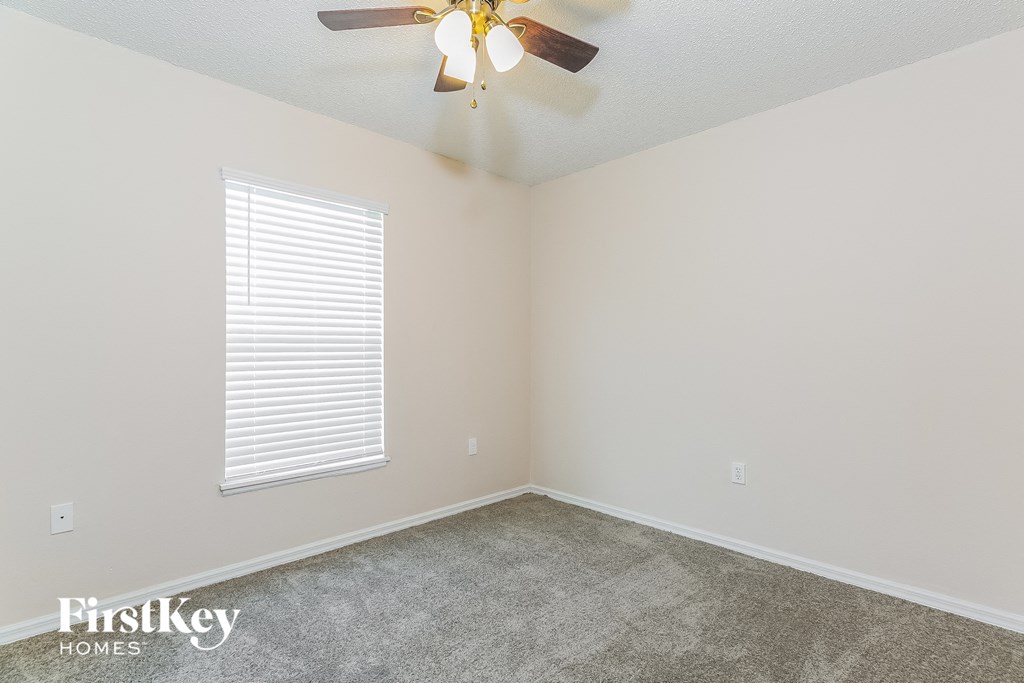 the living room of an empty house with a ceiling fan