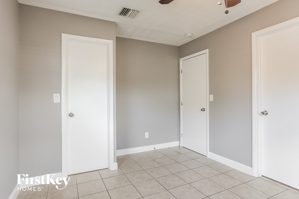 a bedroom with two doors and a tiled floor