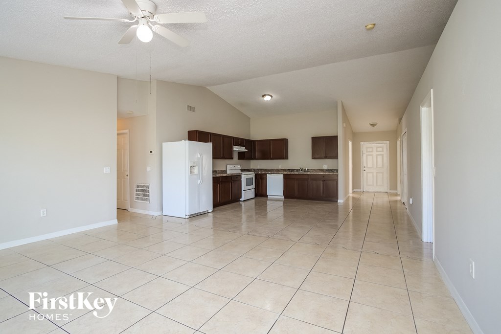 an empty kitchen and living room with tile flooring