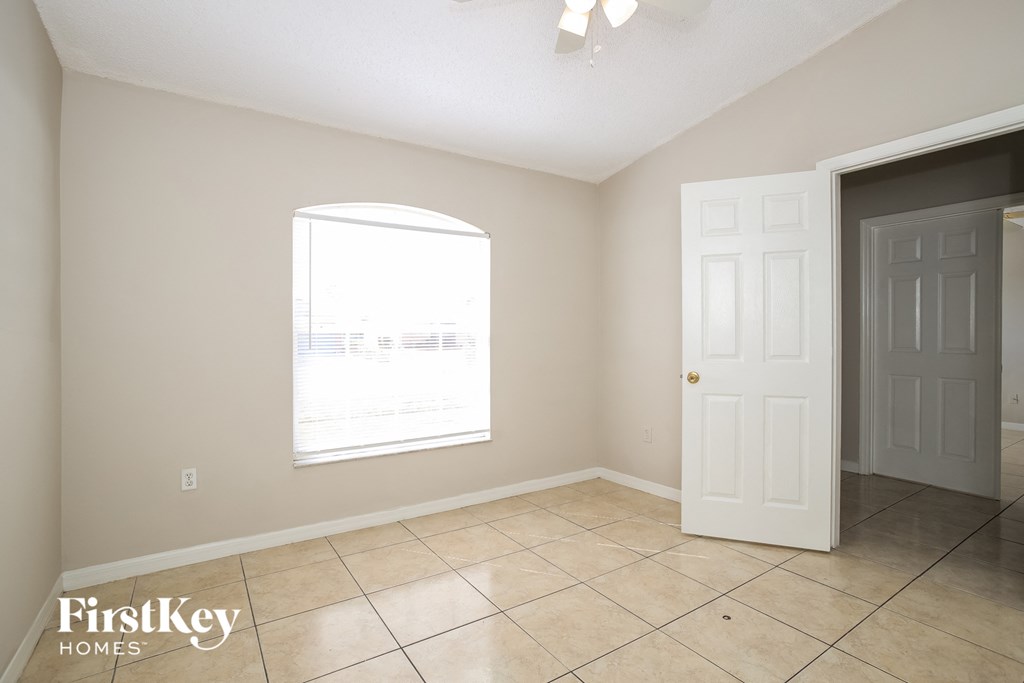 the living room of an empty home with a door and a window