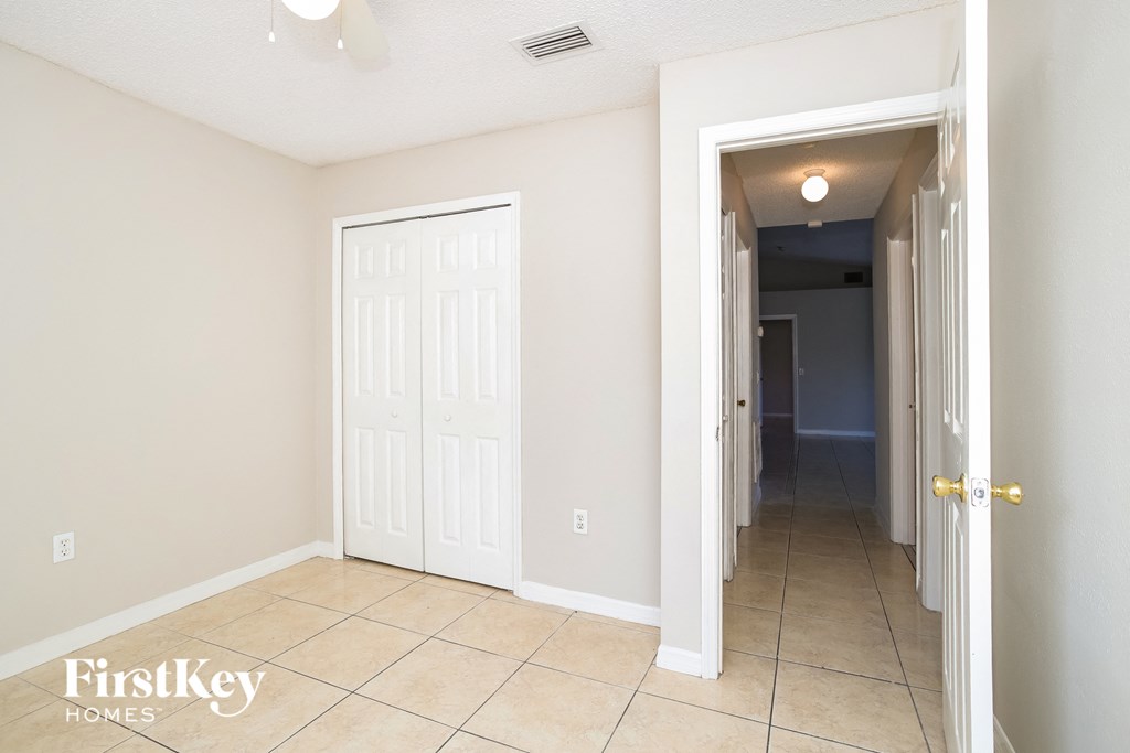 a hallway with two closets and a tiled floor