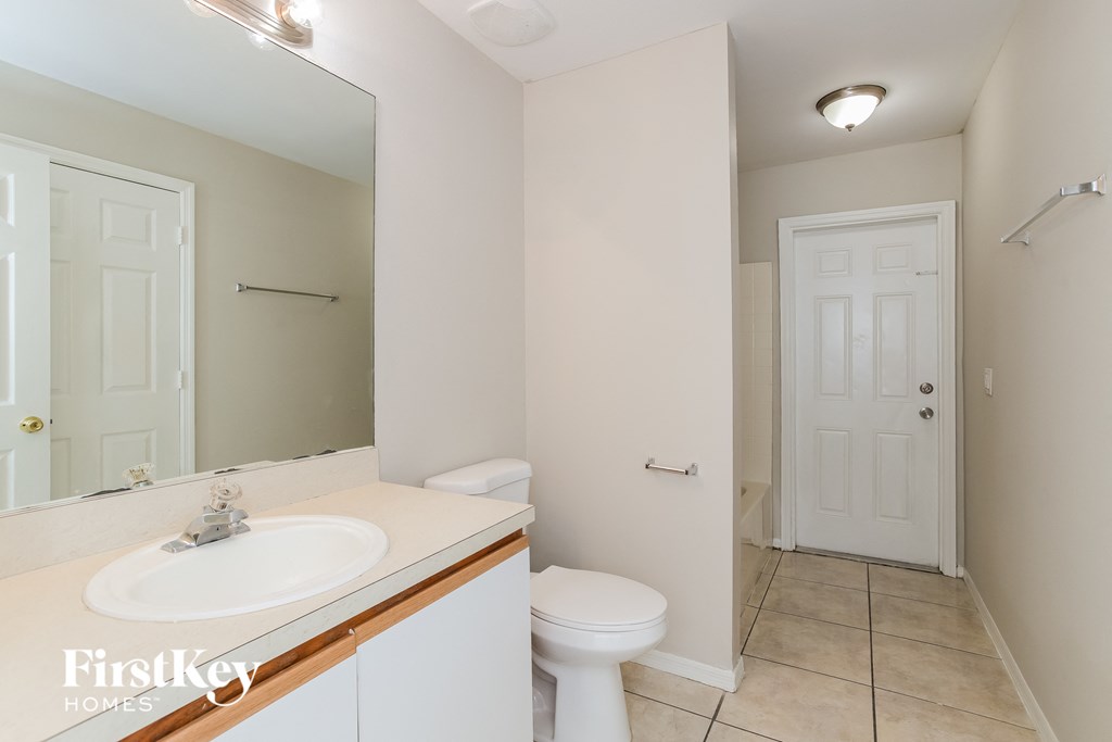 a bathroom with a toilet and a sink and a mirror