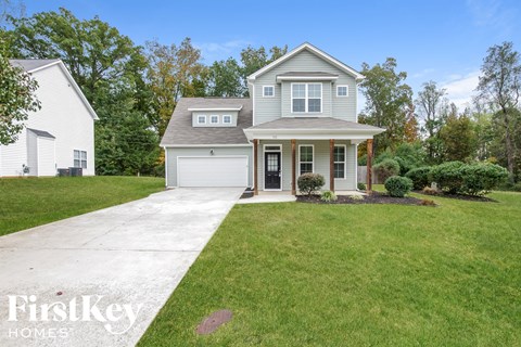 a home with a lawn and a sidewalk in front of it