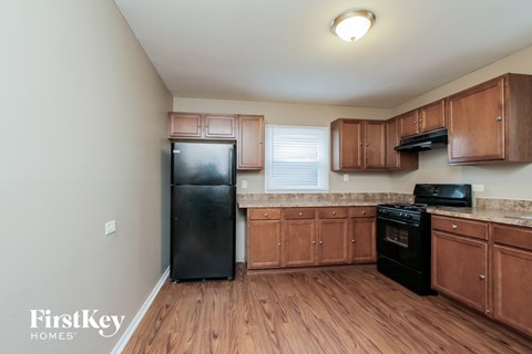 a kitchen with wooden cabinets and a black refrigerator